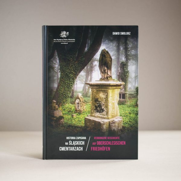 Stojąca pionowo książka Historia zaoisana na śląskich cmentarzach. Na okładce zdjęcie kilku starych nagrobków porośniętych mchem. Z lewej strony pień drzewa porośnięty bluszczem.