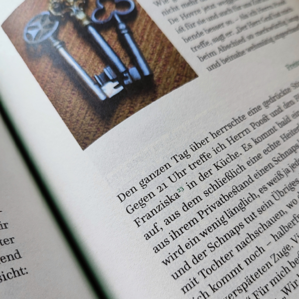 Fragment otwartej książki. W rogu zdjęcie starych kluczy, wkoło tekst w języku niemienckim.
